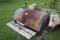 Backyard barrel barbecue with rust and weathered wood