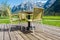 Backyard chair on wooden floor with mountains alps peaks background