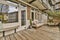 a backyard deck with a couch and chairs and windows