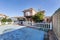 Backyard of a detached house with a swimming pool covered by a blue tarpaulin to pass the winter frosts