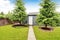 Backyard garage with siding trim, concrete walkway and white door