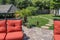 Backyard garden with patio and stepping stones to covered outdoor living area - orange cushioned lawn furniture in foreground with