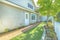 Backyard of a home with brick pathway and rich green lawn viewed on a sunny day