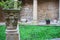 Backyard of unknown medieval monastery with arch and small statue. Small garden in catholic abbey, Camino de Santiago.