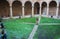 Backyard of unknown medieval monastery with arch and small statue. Small garden in catholic abbey, Camino de Santiago.