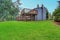 Backyard view of grey rambler house with upper and lower decks