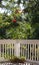 Backyard white fence surrounds the patio featuring a hummingbird feeder and flowers