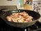 Bacon cooking in frying pan or skillet on stove in kitchen