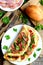 Bacon omelette recipe. Homemade omelette with bacon and parsley on a plate, bacon slices on a plate, bread roll, fork, knife