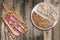 Bacon Rashers On Cutting Board And Integral Brown Bread Loaf Set On Old Weathered Cracked Flaky Wooden Picnic Table