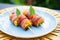 bacon-wrapped pineapple chunks on a tropical themed plate