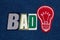 BAD Idea lightbulb and text word collage, colorful fabric on blue denim, business concept