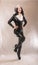 Bad kinky black satna girl posing in latex rubber costume with white fur on dark colorful studio background
