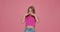 Bad smell. Kid girl pinch nose showing stop gesture, feel disgust on pink studio background. Terrible odor