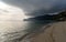 Bad weather moving over mountains onto the ocean and beautiful golden beach