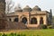 A bada gumbad monument at lodi garden or lodhi gardens in a city park from the side of the lawn at winter foggy morning