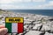 Badge with Irish flag and sign Ireland in focus, Burren landscape and Atlantic ocean out of focus. Travel in Ireland concept