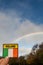 Badge with sign Ireland and National flag in focus, Blue cloudy sky with rainbow in the background. Irish luck concept