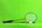 Badminton racket and shuttlecock feathers on light green background with text space.