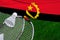Badminton rackets and shuttlecock with flag of Angola on green grass. Badminton championship in Angola
