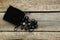 Bag with black rune stones on wooden table, flat lay