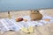 Bag, blanket, wine and other stuff for beach picnic on sandy seashore