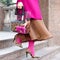 Bag close-up in female hands. Stylish modern and feminine image, style. Girl in pink tights