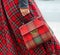 Bag closeup in female hands. Bright image, style. Girl in a red plaid skirt