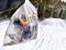 Bag of garbage in hand of woman and snow in forest on the background. A girl cleans up the trash after a picnic. A