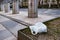 A bag of garbage lies on the lawn on the sidewalk in the city