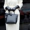 A bag in the hands of a woman. The girl in a trendy coat. Close-up