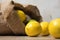 Bag of lemons and lime. Fabric bag with lemons. Full sack of lemons on a wooden background