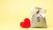 Bag with money and red heart. Valentine`s Day. Saving money. Accumulation. Buying gifts to your loved one. Preparation for the