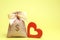 Bag with money and red heart. Valentine`s Day. Saving money. Accumulation. Buying gifts to your loved one. Preparation for the