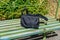 Bag on wooden bench at a railroad station at countryside