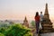 Bagan Myanmar, couple of men and woman looking at the sunrise on top of an old pagoda temple