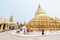 Bagan, Myanmar - March 2019: Buddhist monk walking next to Shwezigon Paya golden temple