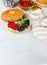 Bagel with cream cheese and fresh berries. On a light wooden background, vertical, with space. Close-up