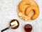 Bagel on cutting board, butter, knife, tea in glass on white concrete background