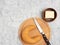 Bagel on cutting board, butter, knife on white concrete background