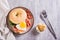 Bagel with heart-shaped boiled egg, tomato, cheese and herbs on a plate. Top view