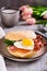 Bagel with heart-shaped boiled egg, tomato, cheese and herbs on a plate. Vertical view