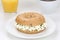 Bagel sandwich for breakfast with cream cheese, orange juice and