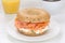 Bagel sandwich for breakfast with salmon fish, orange juice and