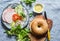 Bagel sandwich with ham, vegetables and green salad on a blue background, top view. Flat lay.