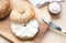 Bagel sesame with spread cream cheese close-up on a wooden cut