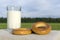 Bagels and glass of milk on a meadow background