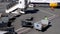 Baggage handler moves an empty luggage cart on an airport tarmac.