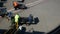 Baggage handlers check and load luggage from carts on an airport tarmac.