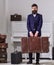 Baggage and travelling concept. Macho stylish on strict face stands and carries big vintage suitcase. Man, traveller